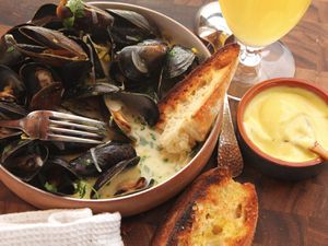 A bowl of moules marinières with toasted bread