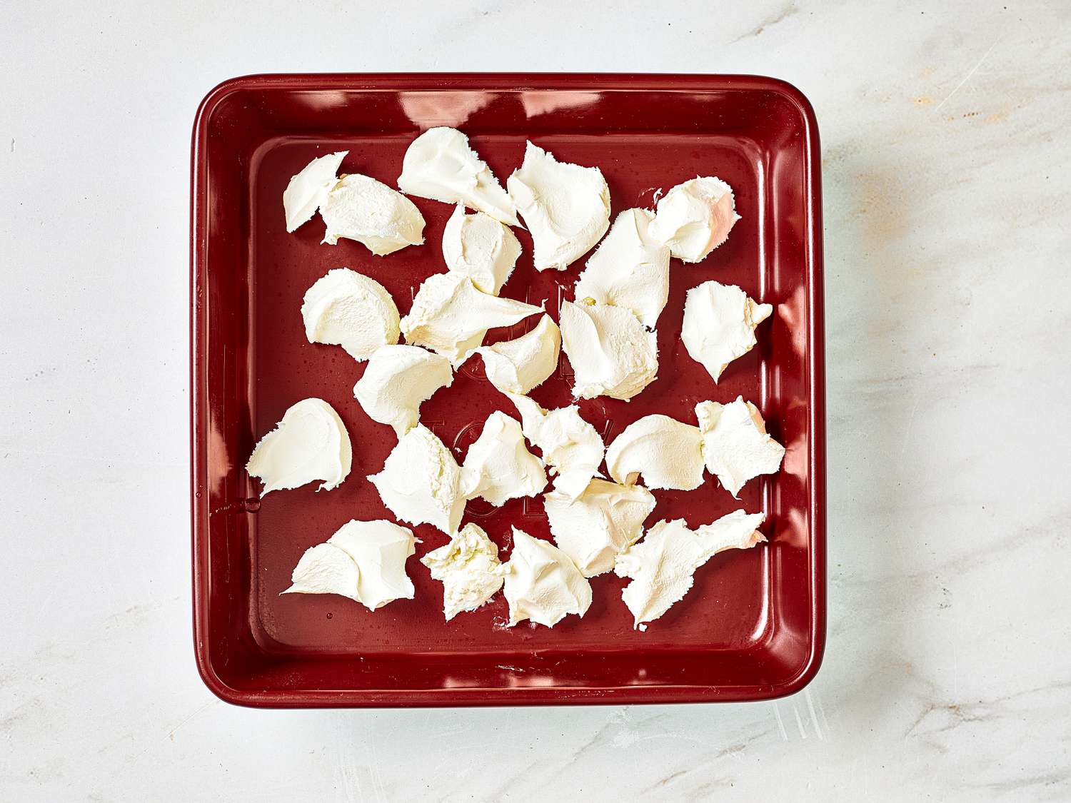 Overhead view of cream cheese broken up into clumps