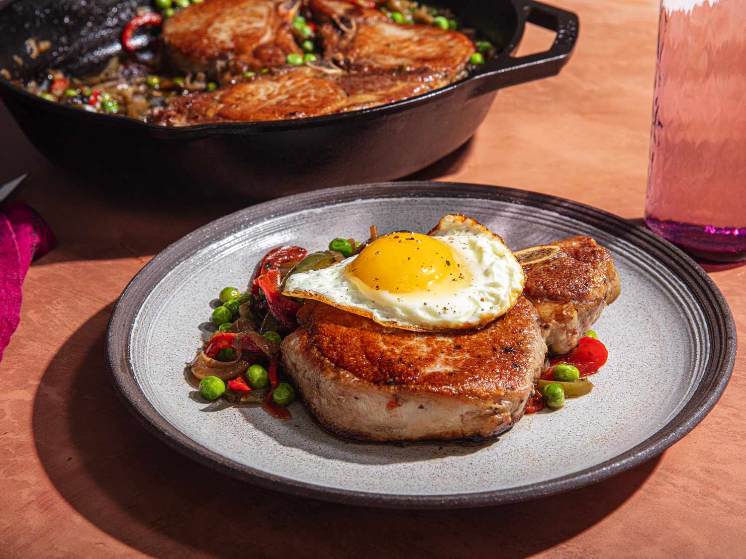 Side angle view of a pork chop topped with an egg