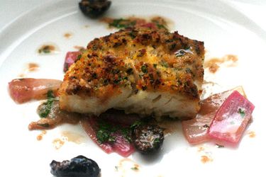 A plate with a piece of Sicilian-style baked cod.