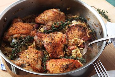 Serving up crispy braised chicken thighs with cabbage and bacon from a deep skillet