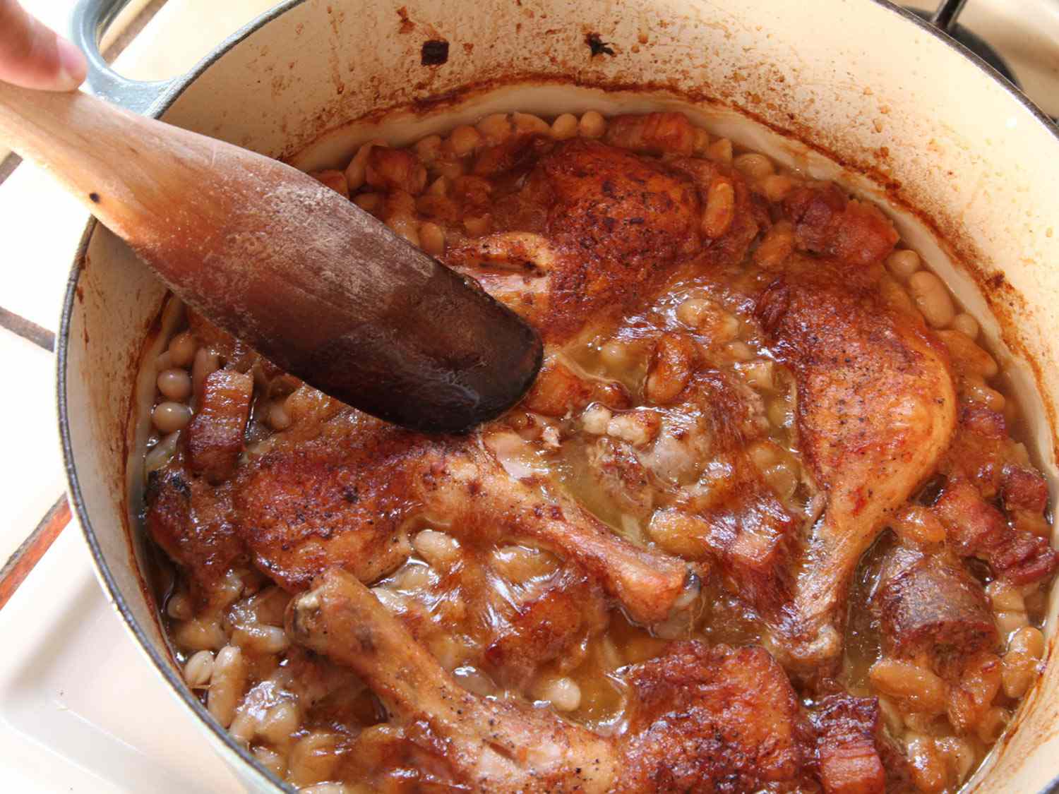 Cassoulet baked in a Dutch oven showing very little crispy skin on top.