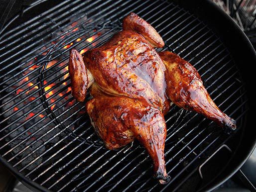 烤炉上的蝴蝶鸡，鸡胸朝上，涂上一层新鲜的烧烤酱，闪闪发光。