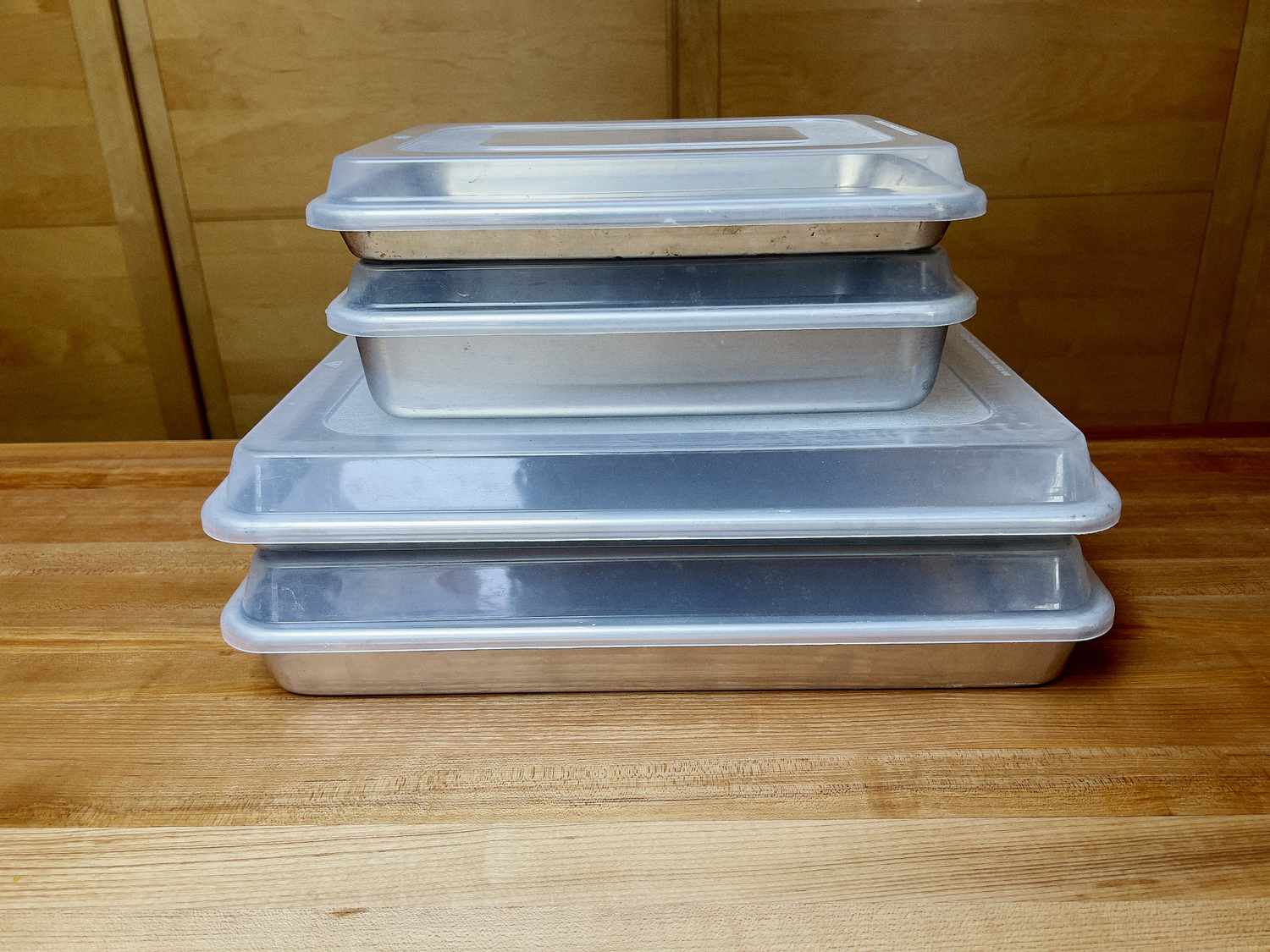 a stack of differently sized sheet pans with lids on them