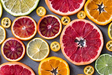 An overhead view of colorful citrus wheels of different sizes an shades of orange, yellow, green, red, and pink.