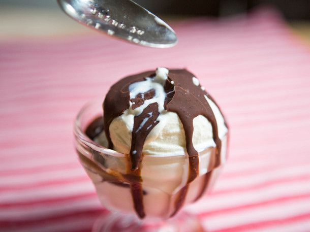 一碗淋上巧克力酱的冰淇淋。在巧克力酱上方的画框里有一个勺子，刚刚敲过它。涂层破裂了，融化的冰淇淋正从裂缝中渗出。gydF4y2Ba