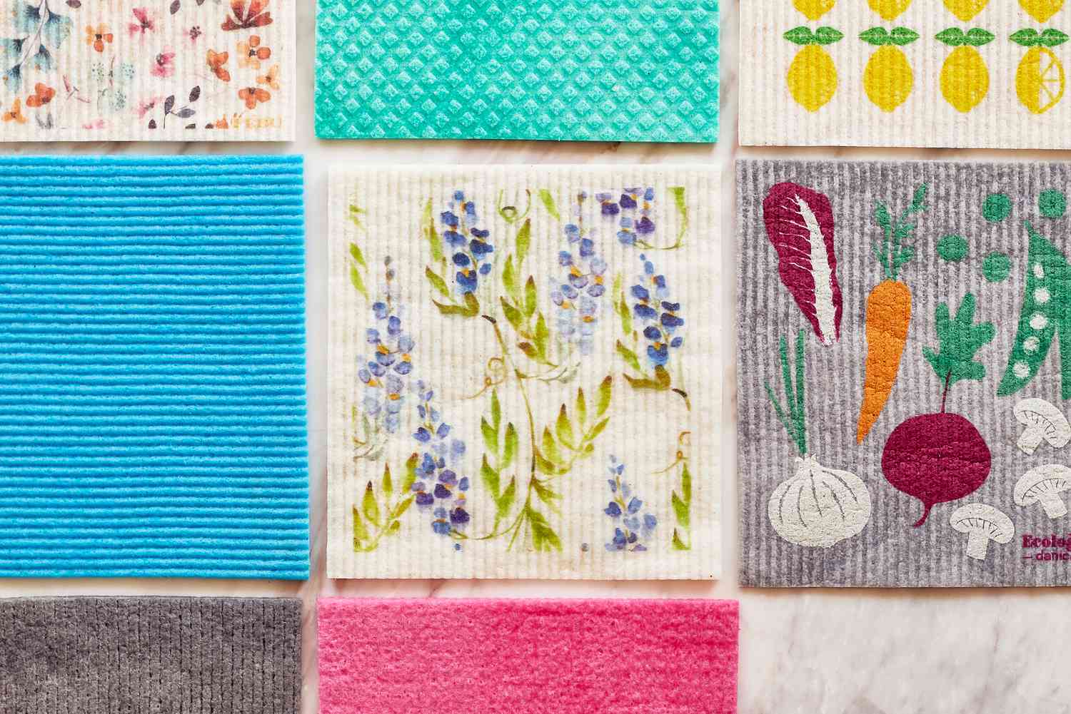 multiple wet swedish dishcloths on a marble surface