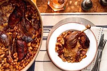 Overhead view of a single single serving of traditional French Cassoulet next to the pot