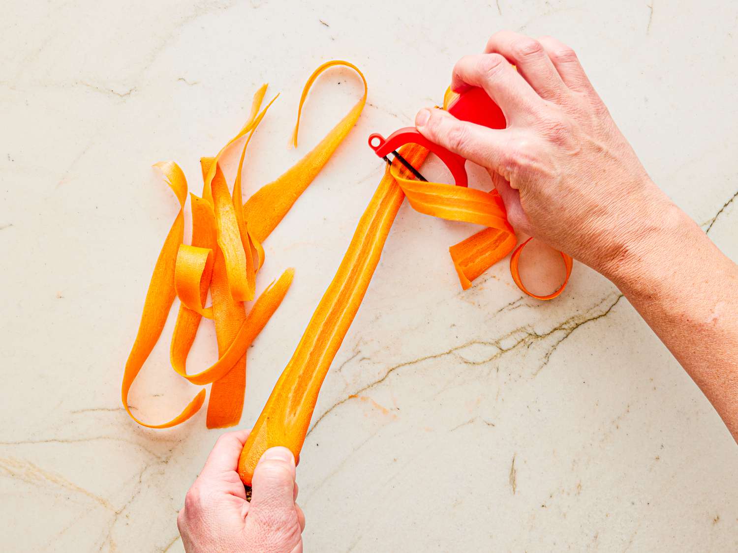 Overhead view of peeling carrot ribbon threads