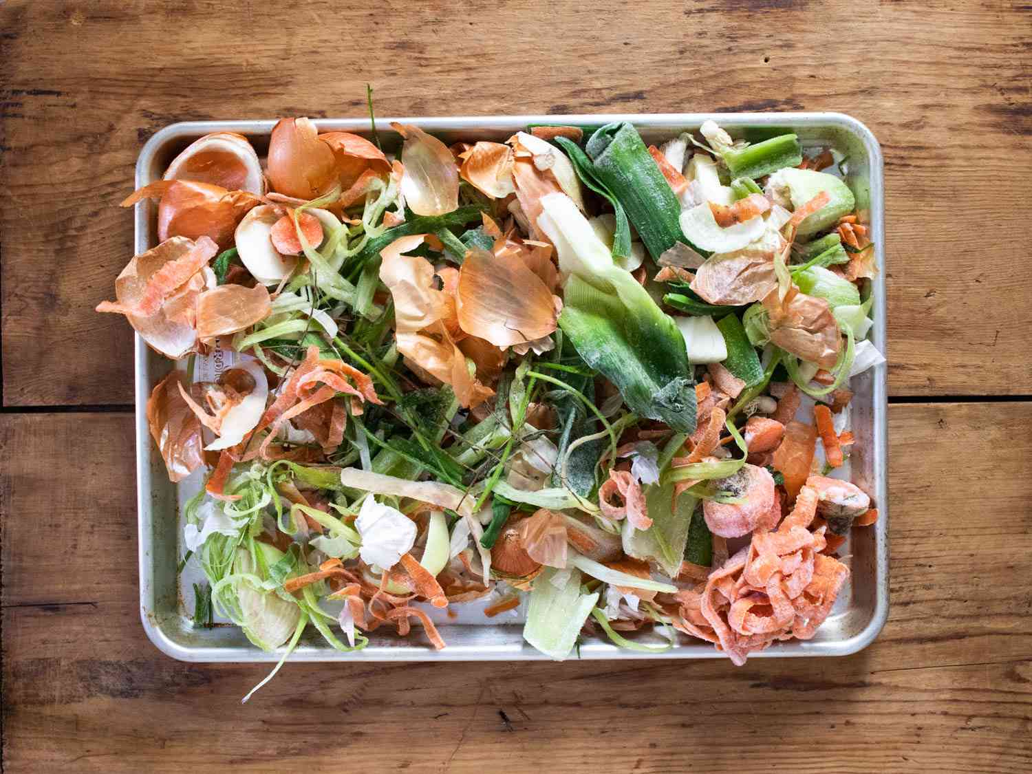 Frozen vegetable scraps unbagged and placed on a sheet pan.