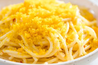 Bottarga grated over a bowl of spaghetti