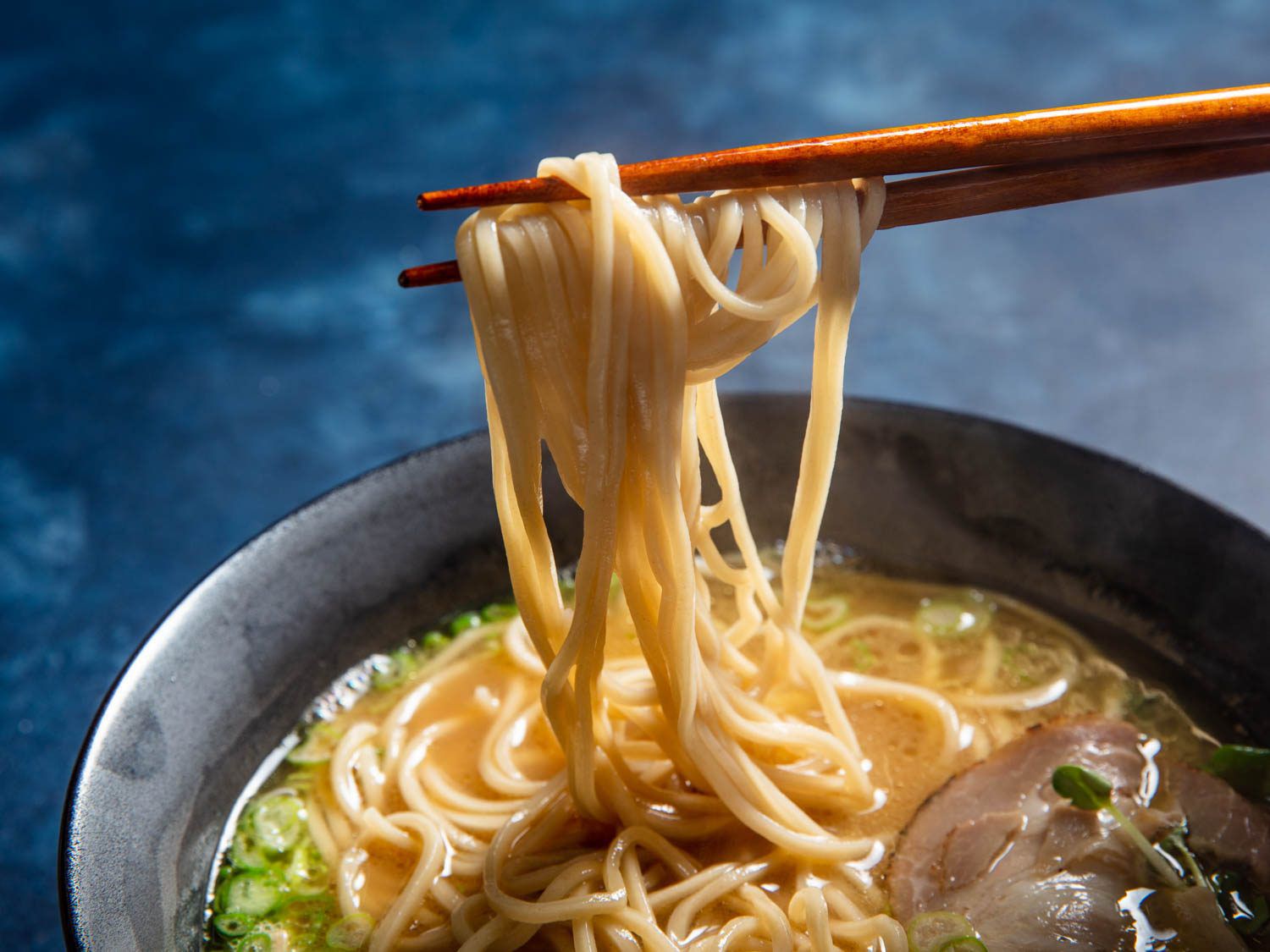用筷子从一碗拉面中抽出自制的碱性面条