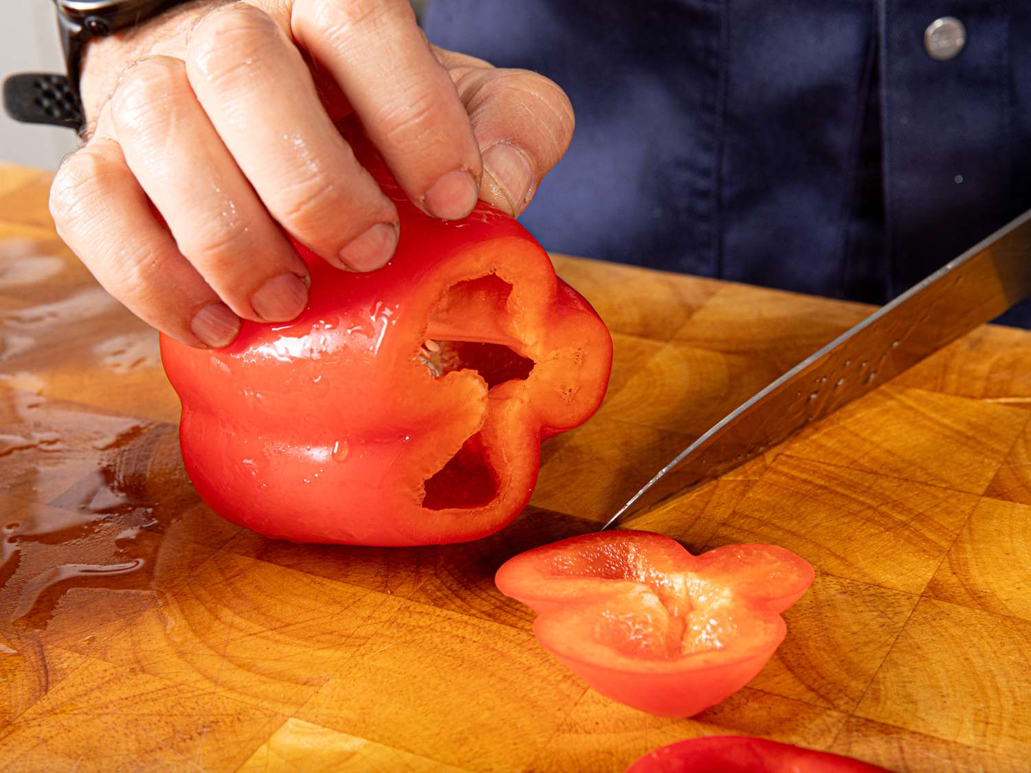 Side view of cutting off bottom of bell pepper