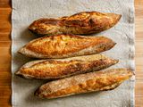 Overhead view of 4 baguettes on a grey table runner