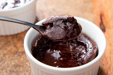 Lifting a spoonful of molten chocolate lava cake out of a ramekin