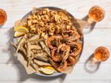 A large platter of fritto misto di mare with fried shrimp, squid, and smelt.