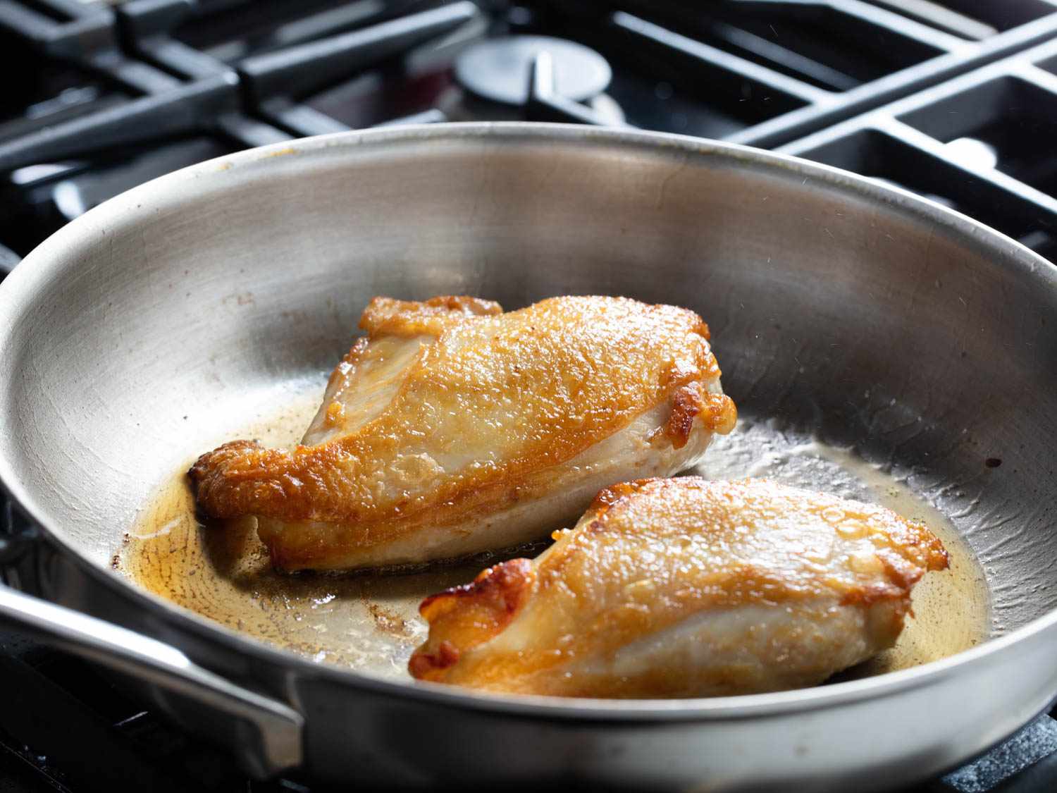 把鸡胸肉放在煎锅里煎，鸡皮呈金黄色