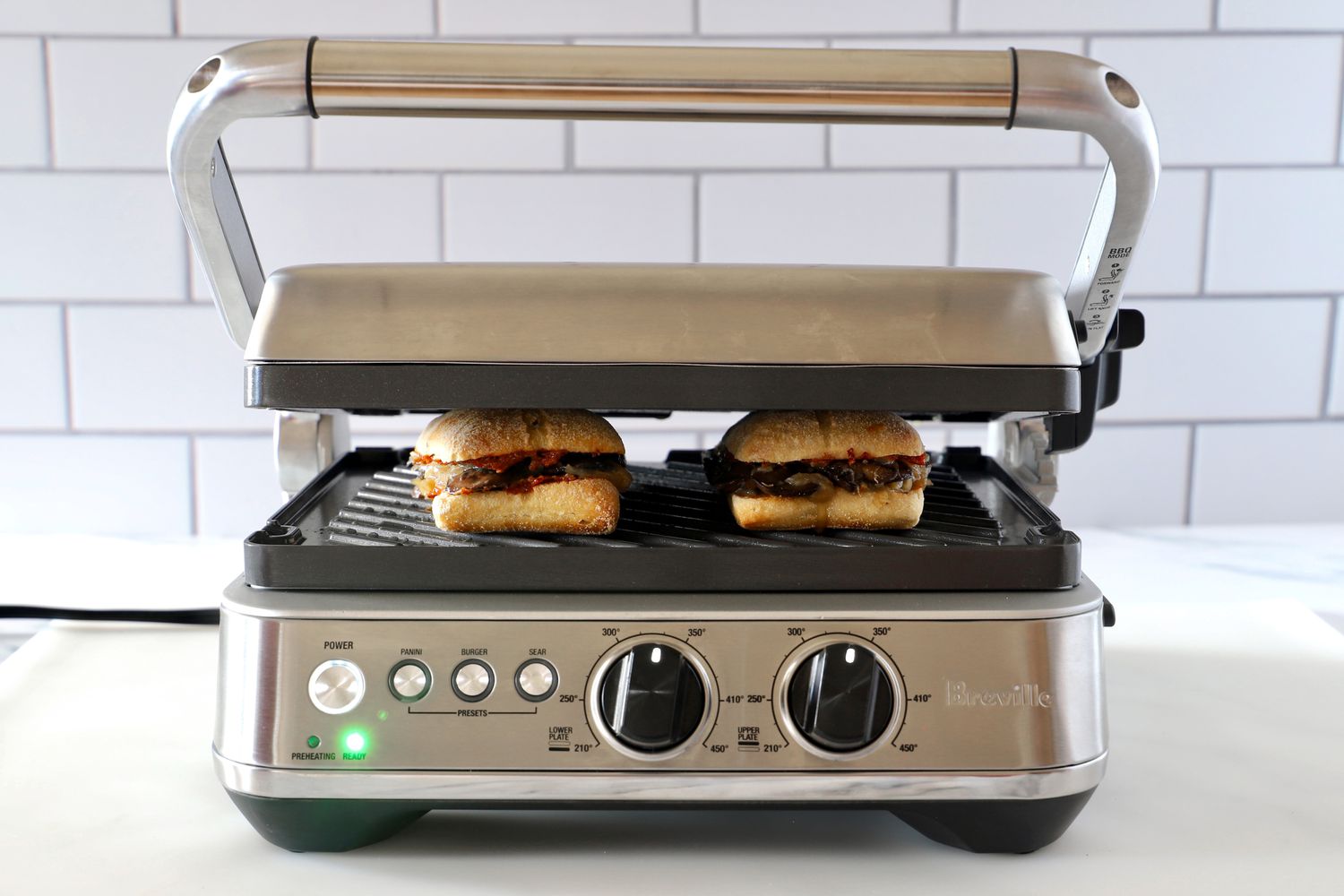 a panini press pressing two vegetarian sandwiches