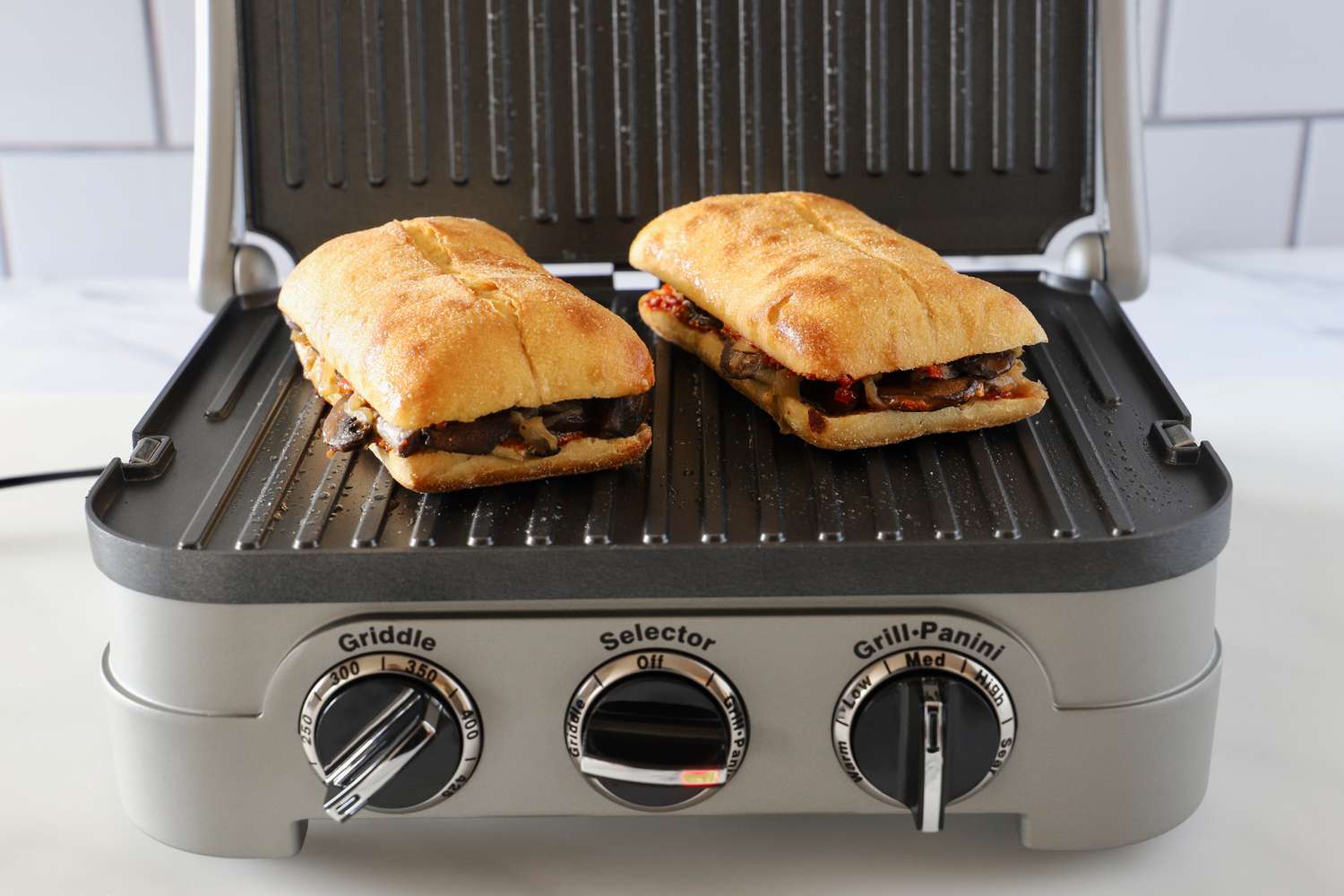 two sandwiches on the grates of a panini press