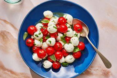 Marinated mozzarella, cherry tomato, and basil salad inside a dish