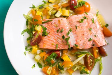在夏季蔬菜和肉汤的基础上轻轻煮熟的鲑鱼片
