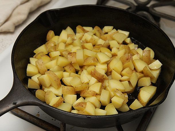 在铸铁锅里煮土豆丁。