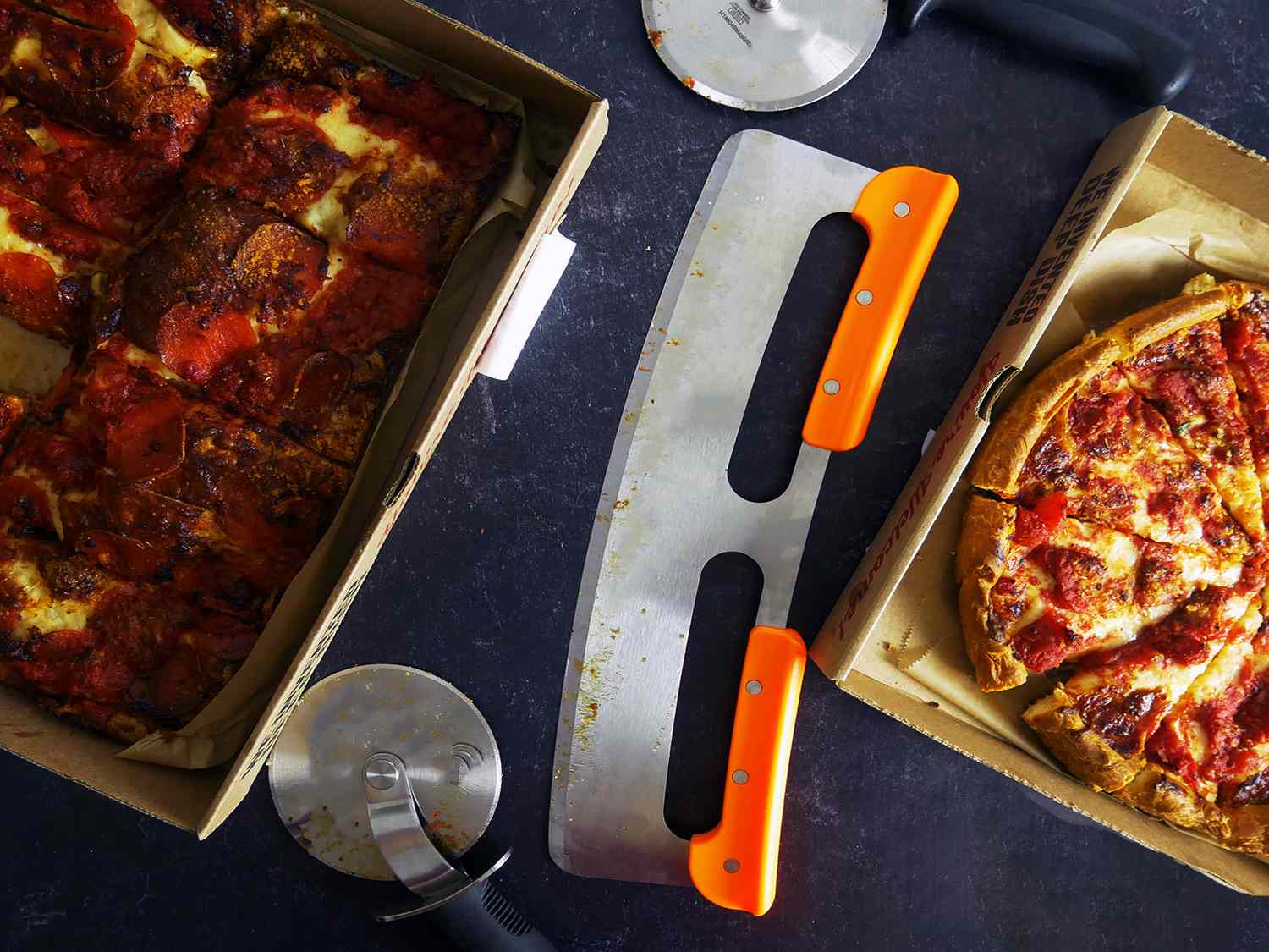 our favorite cutters with two pizzas on a black countertop