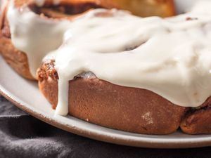 Close-up of overnight cinnamon rolls topped with cream cheese frosting.