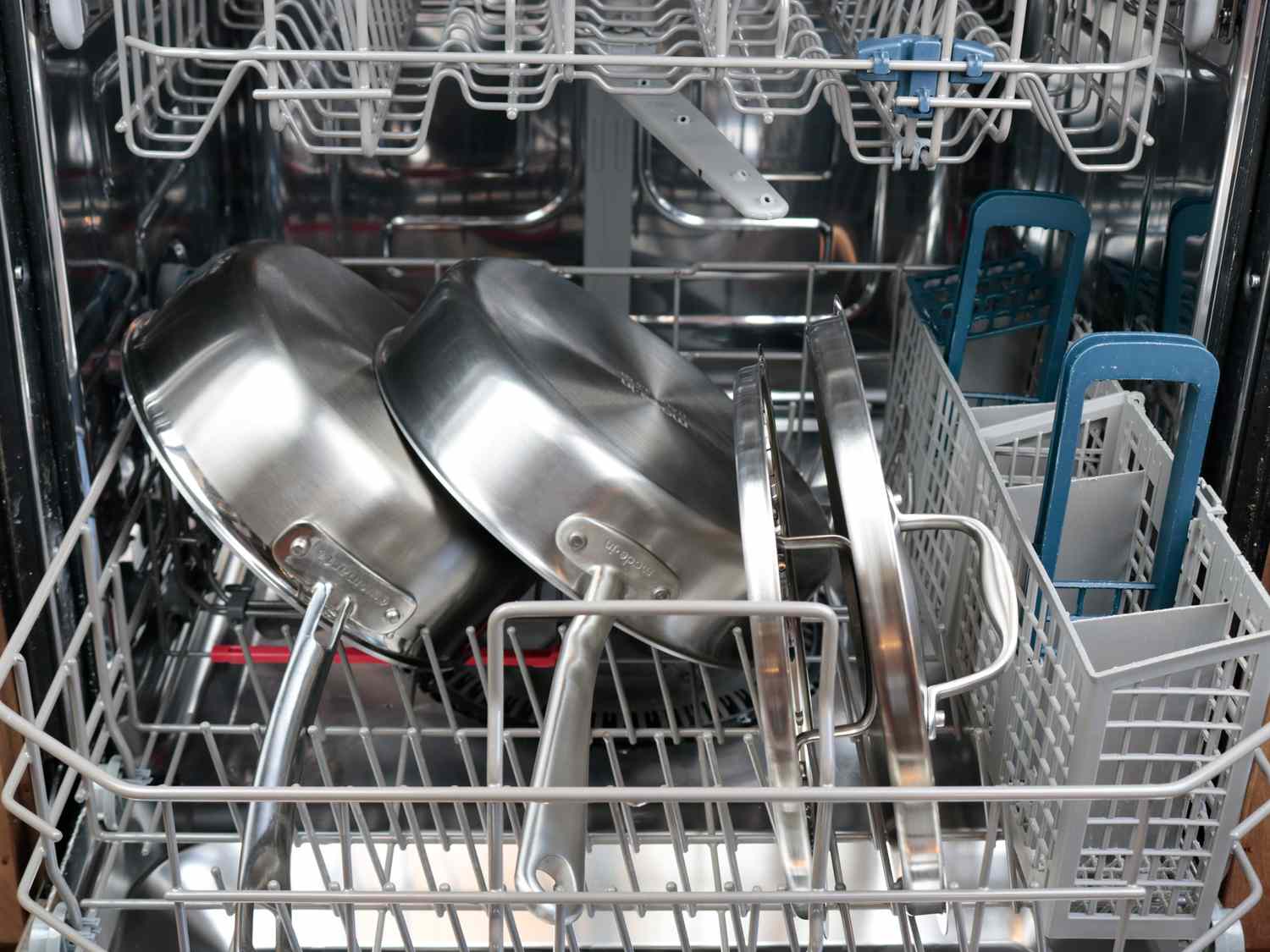 two stainless steel saute pans in a dishwasher rack