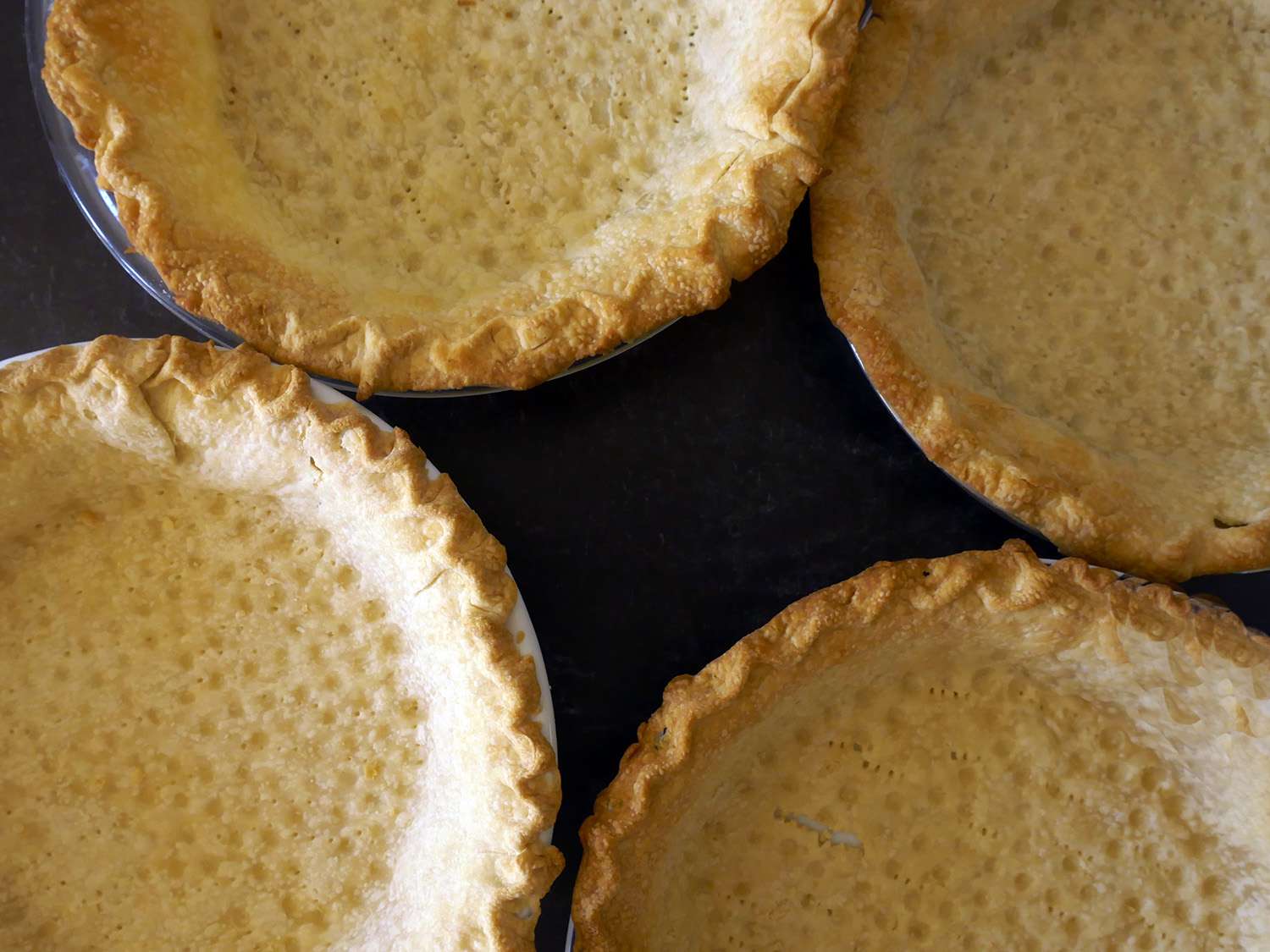 an overhead shot of cooked crusts in pie pans