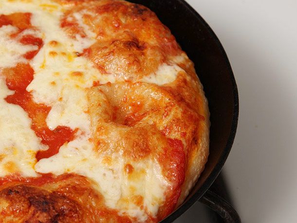 在铸铁锅里烤的披萨，配上番茄酱和白奶酪。gydF4y2Ba