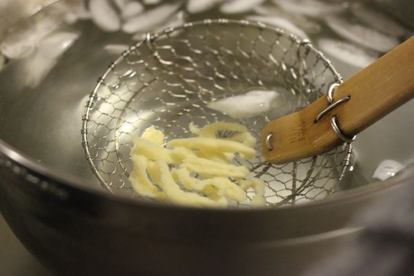 作者舀出烹饪和冷却spätzle从冰浴。