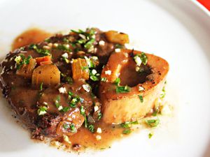 A serving of gravy-covered osso bucco sprinkled with gremolata