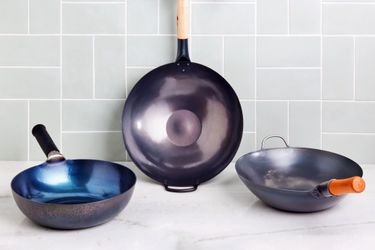 three woks on a kitchen surface