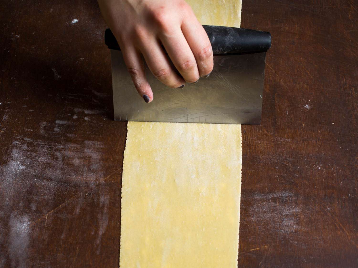 用台式刮刀将意大利面面团分成两半