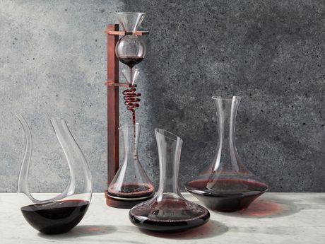 four different styles of wine decanters against a grey background