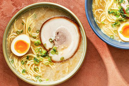 一碗自制的顶部设有一个骨拉面——马rinated egg which has been sliced in half, and a slice of pork chashu.