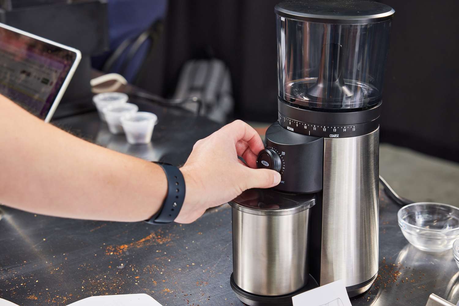 A hand turning the time dial of the OXO burr grinder