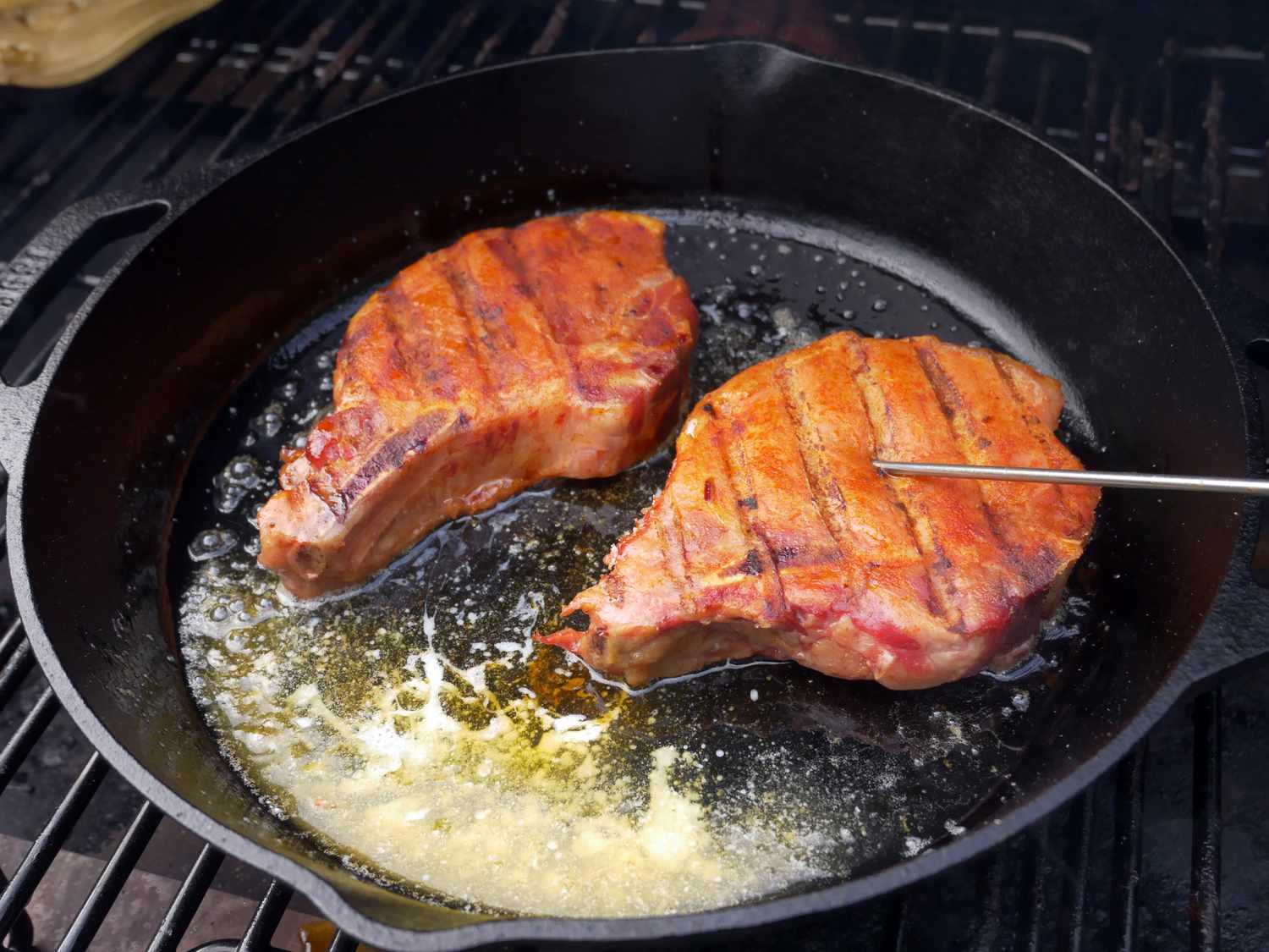 smoked pork chops in cast iron pan on grill