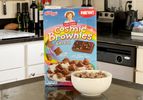 Box of Kellog's Little Debbie Cosmic Brownies Cereal on a counter with a bowl filled with the cereal in the foreground