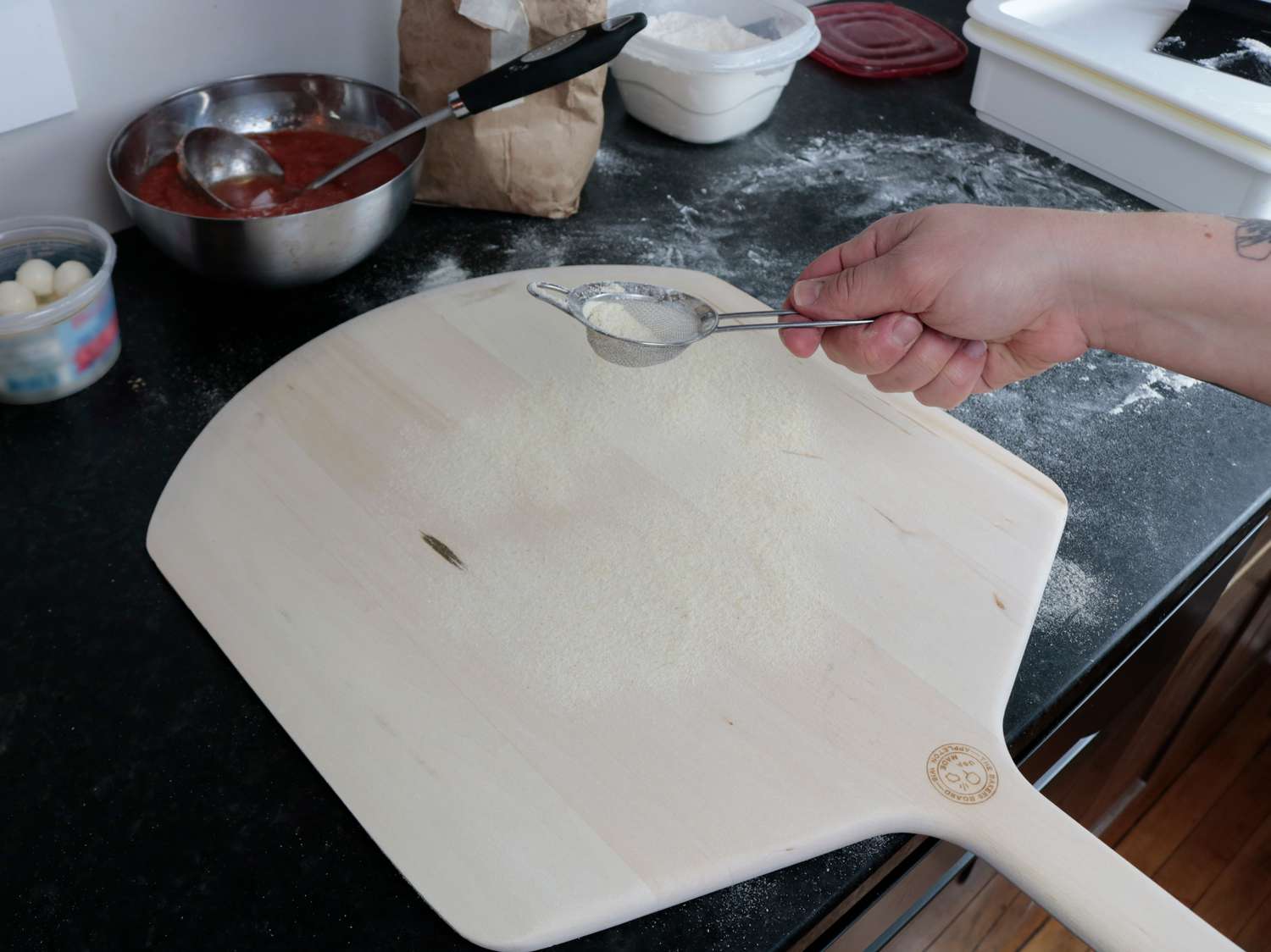 semolina flour is dusted on a wooden pizza peel