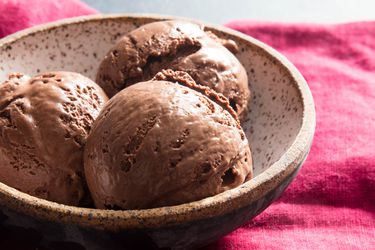 一碗巧克力冰淇淋放在红色毛巾上。