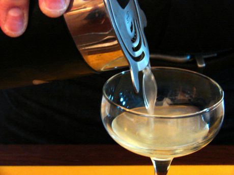 Straining a cocktail into a coupe glass
