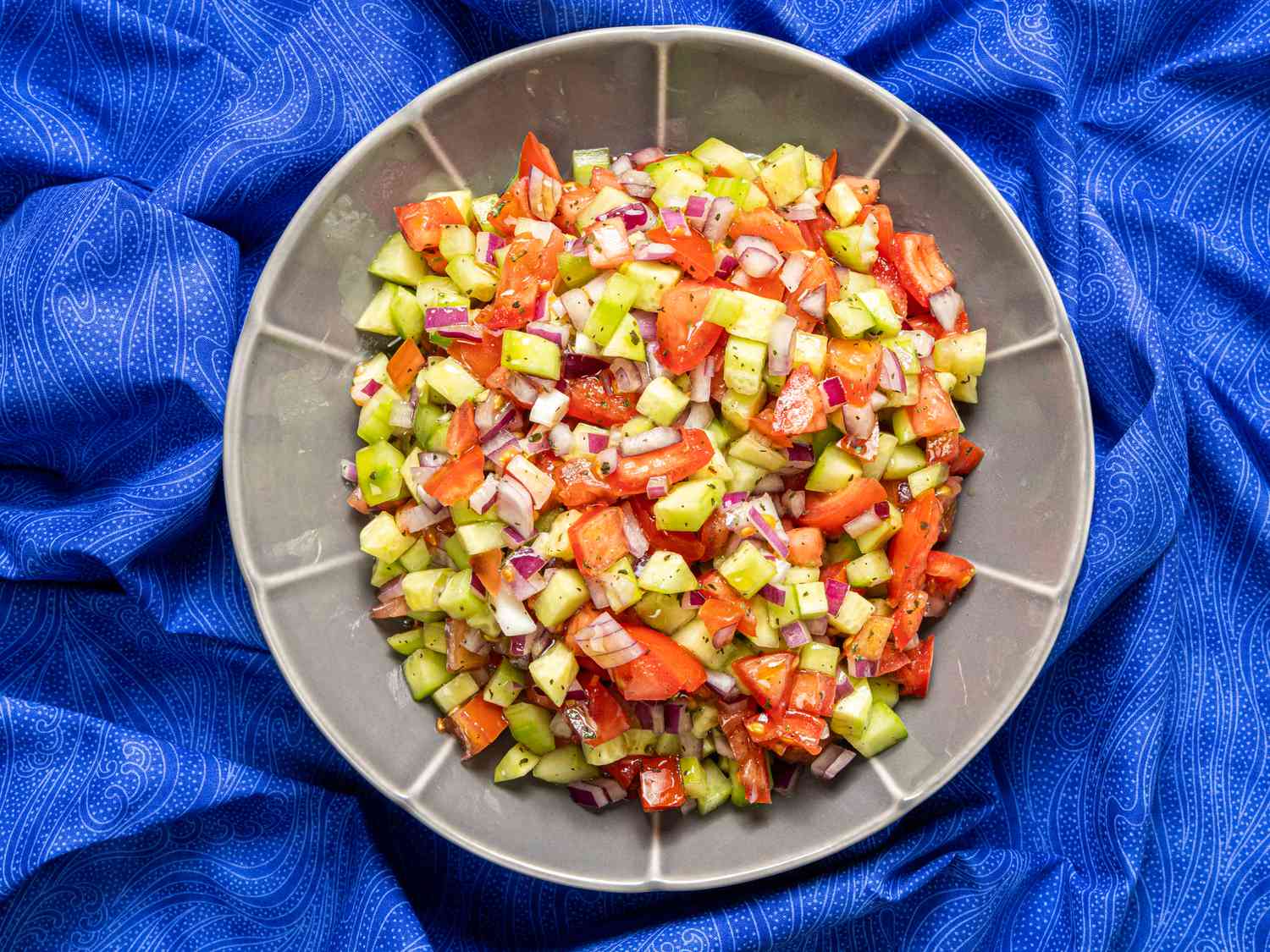 Overhead view of shirazi salad on a blue background