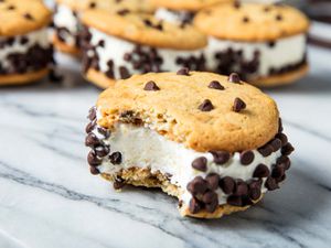 Ice cream sandwiches made with chocolate chip cookies and vanilla ice cream, with mini-chocolate chips rolled on the sides.