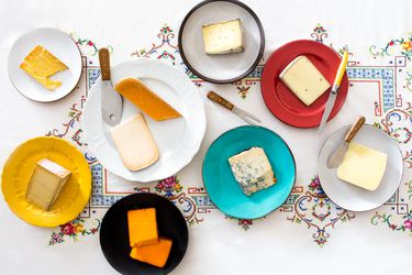 各种各样的奶酪，每一种都用奶酪刀放在一个单独的盘子里。
