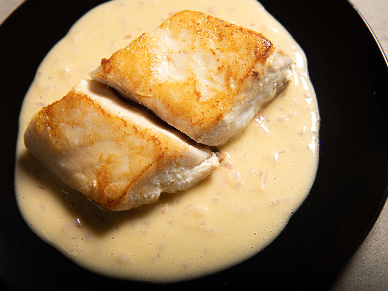 Overhead view of fish plated on top of Beurre Blanc sauce