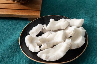 开销竞争w of coconut pieces on a black plate