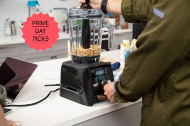 a person using a Vitamix blender to make peanut butter