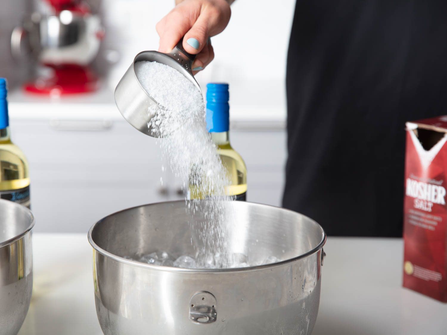 Pouring salt into bowl of ice and water.